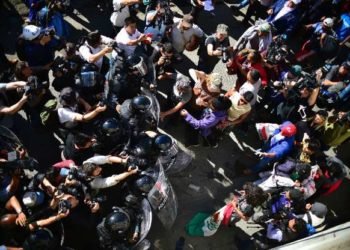 Migrantes se retiran después de bloqueo policial a la frontera entre México y Estados Unidos